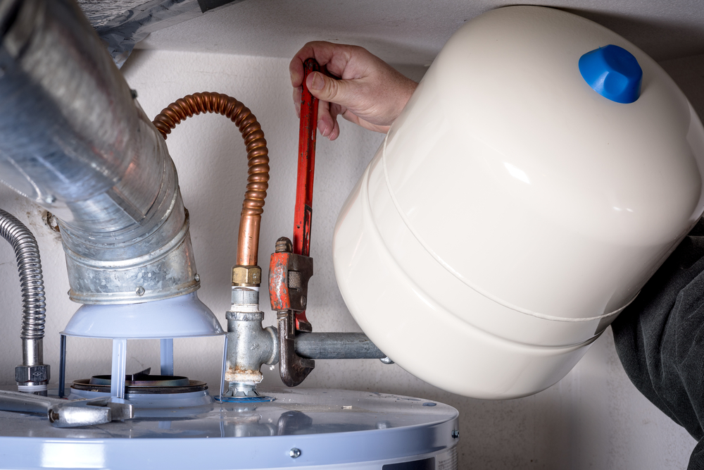 A plumber performing a service on a water heater.