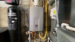 A tankless water heater with connected pipes and a water filtration system in a basement setting.