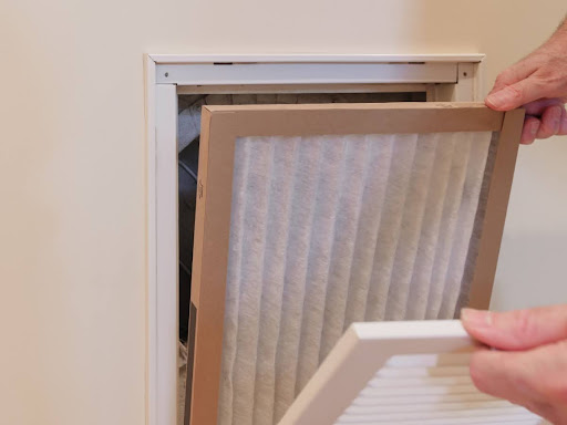 Someone installing a new HVAC air filter.
