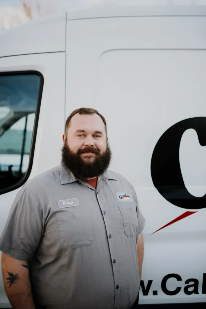 A friendly Connors Plumbing, Heating, Air, & Electrical team member stands by a branded service van, ready to help customers.